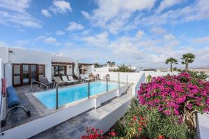 普拉亚布兰卡VILLAS LANZAROTE LOS ALTOS by NEW LANZASUITES Villa SERENA的一座带游泳池和鲜花的别墅