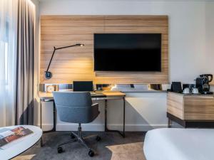 阿姆斯特丹阿姆斯特丹市诺富特酒店的配有书桌、显示器和椅子的房间