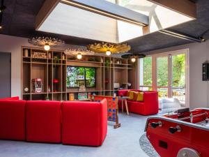 贡比涅贡比涅宜必思酒店的客厅配有红色家具和大窗户