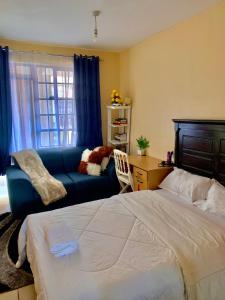 内罗毕Comfort Studio的一间卧室配有一张床和一张蓝色的沙发