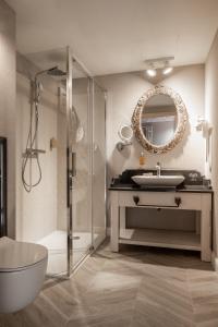 布科维纳-塔钱斯卡Apartamenty Aries Residence Bukowina的一间带水槽、淋浴和镜子的浴室
