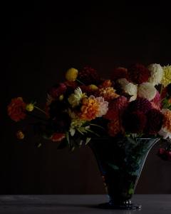 斯德哥尔摩Villa Dahlia的花瓶里满是五颜六色的花朵,坐在桌子上