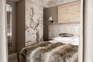 布科维纳-塔钱斯卡Aries Residence Bukowina的卧室配有一张床,墙上挂有绘画作品