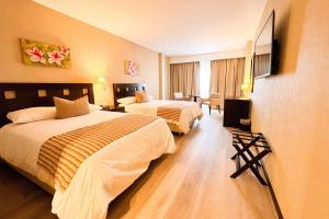 富内斯Howard Johnson Hotel & Resort Funes的酒店客房设有两张床和电视。