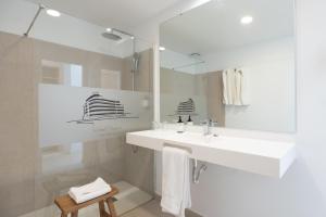 厄尔梅达诺梅达诺酒店的白色的浴室设有水槽和镜子