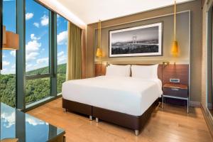 伊斯坦布尔Radisson Collection Hotel, Vadistanbul的一间卧室设有一张大床和大窗户