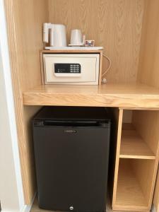 米尔芳提斯城Charm-In Center的一间带微波炉和冰箱的小厨房