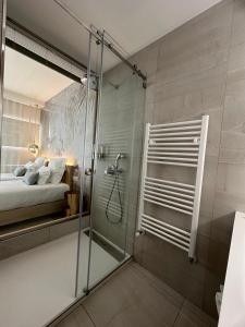 米尔芳提斯城Charm-In Center的一间带玻璃淋浴的浴室和一张床