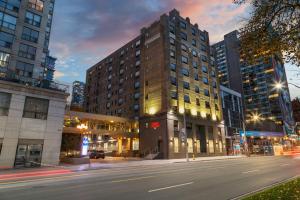 多伦多Hampton Inn & Suites by Hilton Toronto Downtown的夜幕降临的城市街道上一座高楼