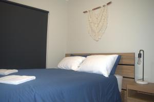 罗克斯比唐斯Modern Apartment in Roxby Downs的一间卧室配有一张带蓝色床单和白色枕头的床。