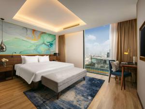 河内Mövenpick Living West Hanoi的酒店客房设有一张床和一个大窗户