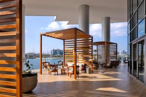 迪拜Hilton Dubai Creek Hotel & Residences的阳台配有桌椅,享有水景。