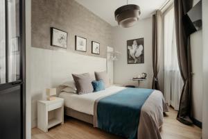 巴黎阿尔根松酒店的一间卧室配有一张带蓝色毯子的床