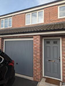 BentleyFreshen-up stays Doncaster的一个带灰色门和砖砌建筑的车库