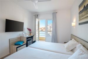 厄尔梅达诺梅达诺酒店的一间卧室配有一张大床和电视
