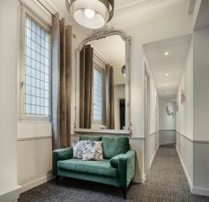 巴黎阿尔根松酒店的客厅配有绿色沙发和镜子