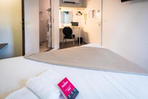 里摩日Fasthôtel - Un hôtel FH Confort的一间医院房间,里面有一床,上面有红色的标志