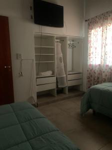 圣马丁Almirante Brown 235 , Dpto 5的卧室配有一张床,墙上配有电视。