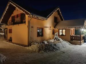 韦伯夫林伯维德沃尔旅馆的雪覆盖的房屋,晚上有灯