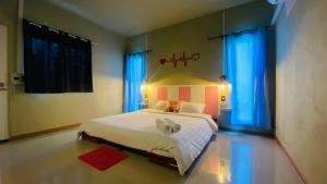 Ban Phang Khwang Taiพิมานอินทร์ รีสอร์ท的卧室配有一张带蓝色窗帘的大型白色床
