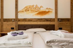 索拉加Wellness Hotel Dolomia的一间设有两张带毛巾的床的客房,享有山景