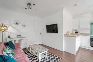格拉斯哥BrightCentral Apartment With Parking的一间带粉色沙发的客厅和一间厨房