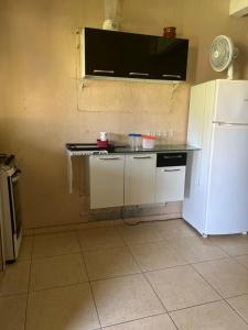 大普拉亚Pousada Recanto do Zeca casa 3的厨房配有柜台和白色冰箱。