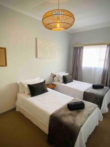 亨蒂斯湾Beachfront 3 bedroom house的酒店客房设有两张床和吊灯。