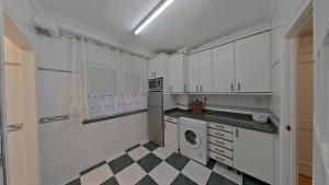 桑托尼亚Casa Angela的厨房配有白色橱柜和 ⁇ 格地板