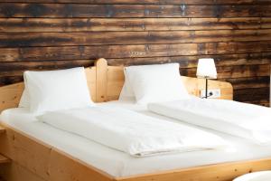 费尔德基兴费西格尔旅馆的卧室内的两张床,配有白色床单和枕头