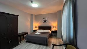 宿务Hotel Capada的配有一张床和一张书桌的酒店客房