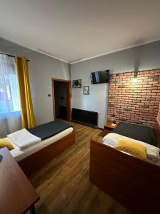 科希强Hotel Nenufar Premium的酒店客房带两张床和砖墙