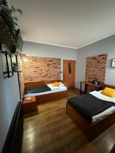 科希强Hotel Nenufar Premium的一间卧室设有两张床和砖墙