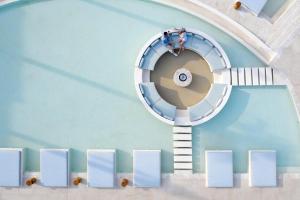 阿菲托斯Cora Hotel & Spa的游泳池里的一个螺旋楼梯,上面有人