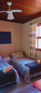 布希奥斯格力巴民宿的一间卧室配有两张床和吊扇