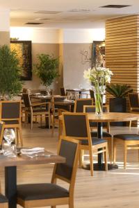 德龙河畔洛里奥勒Logis Hotel Restaurant SPA Les Oliviers的一间带木桌和椅子的餐厅,