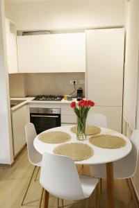 罗马Apartment Cinecittà的白色的厨房配有桌子和白色椅子