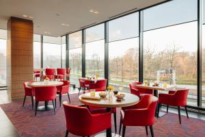 海牙巴比伦海牙酒店 的餐厅设有桌椅和大窗户。