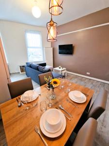 利物浦Nice and comfy 1 bedroom apartment!的用餐室配有木桌、盘子和酒杯