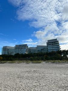 米兹多洛杰WAVE 10th Floor Baltic View的沙滩前两栋海滩上的建筑