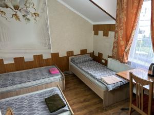 DrogovyzheГотель Максим的一间设有两张床和一张桌子的房间