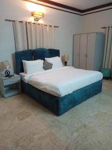 卡拉奇Bondi Beach Resort的一间卧室配有一张大床和蓝色床头板