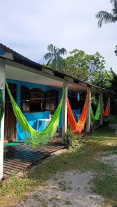 蜜岛Pousada e Camping da Rhaiana - Ilha do Mel - PR的房屋设有吊床,可从前廊悬挂
