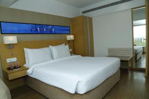 艾哈迈达巴德Sarovar Portico Rivera Ahmedabad的一张大白色的床,位于酒店客房内