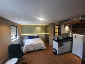 圣保罗FLAT HOTEL DOIS QUARTOS AV IBIRAPUERA 2927的一间带床的小卧室和一间厨房