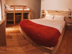 平佐洛B&B Maso Ghirola的一间卧室配有一张带红色毯子的大床