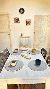菲乌米奇诺Casa vacanze profumo di mare的一张桌子,上面有三个杯子和盘子