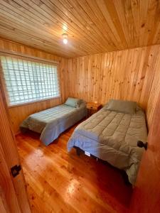 瓦尔迪维亚Cabañas Vista al Mar的小木屋内一间卧室,配有两张床