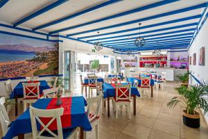 卡门港全景公寓酒店 - 仅限成人入住的餐厅设有蓝色和红色的桌椅