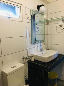 努沃勒埃利耶Aquaa Leaf Residences的一间带水槽、卫生间和镜子的浴室
